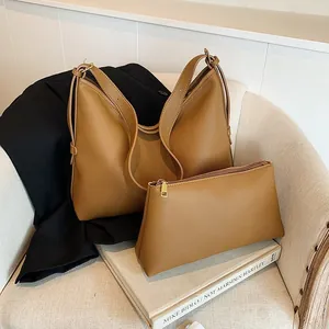 Dettaglio della borsa hobo in pelle color caramello con piccola pochette coordinata