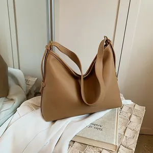 Dettaglio della borsa tote marrone in pelle con motivo litchi e fibbia dorata