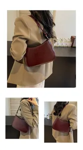 Detail view of a vintage dark red faux leather hobo bag with adjustable metal buckle strap