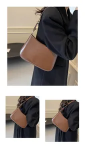 Detail view of brown matte leather shoulder bag with embossed logo and fine texture