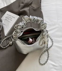 Silver metallic pleated handbag showing spacious interior with zipper and pearl charm