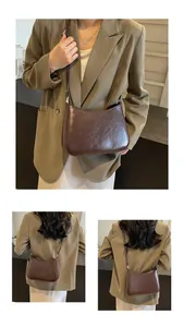 Detail of dark brown oil-wax leather shoulder bag showing texture and stitching on strap