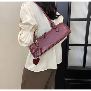 Dettaglio della borsa baguette rosso scuro in pelle lucida a pieghe con cuore