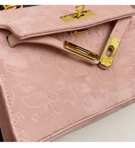 Close-up of pink embossed leather with cartoon patterns and gold metal Kelly lock detail