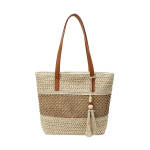 Fashion woven straw tote bag with brown leather handles and decorative tassel detail