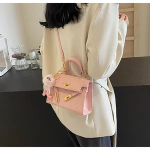 Pink structured handbag with cartoon embossing and a cute plush monster charm