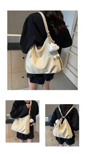 Detail of soft cream PU leather tote bag featuring brand logo and plush cloud charm