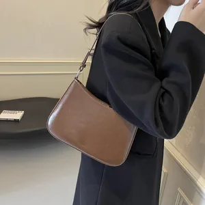Detail of a minimalist dark brown leather shoulder bag with 'NO FILTER' engraving