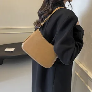 Detail of camel leather shoulder bag featuring an adjustable strap and NOFILTER branding