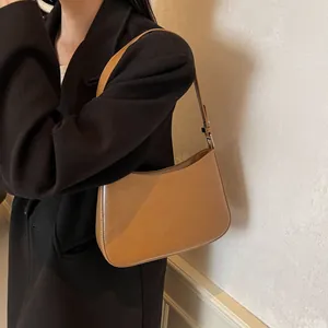 Detail of caramel crescent underarm bag with matte leather and adjustable strap