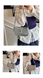Detail view of silver metallic baguette shoulder bag with glossy mirror finish and buckle