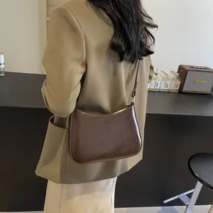 Detail of minimalist dark brown leather underarm bag with NO FILTER logo and smooth texture