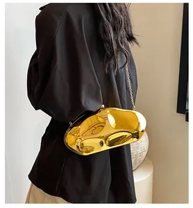 Detail view of irregular geometric gold metallic clutch bag with mirror finish and chain