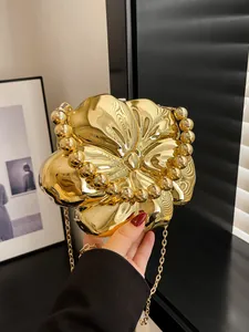 Dettaglio della borsa dorata a forma di fiore con finitura a specchio e manico