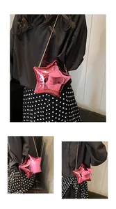 Detalle del bolso rosa con forma de estrella, acabado metálico y correa de cadena dorada