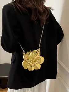 Dettaglio della borsa creativa a forma di fiore dorato indossata su un blazer nero