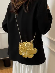 Vista posteriore della modella con borsa da sera dorata a forma di fiore e catena