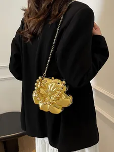 Elegante borsa a forma di fiore dorato con catena sottile sulla spalla della modella