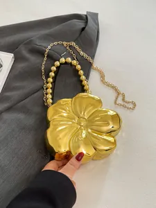 Dettaglio borsa a scatola dorata a forma di fiore con manico a perline e tracolla a catena