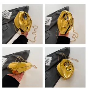 Detailed macro view of gold irregular liquid metal clutch bag with a sleek gold chain strap
