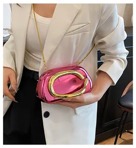 Macro detail of luxury metallic pink evening bag with oversized gold handle ring