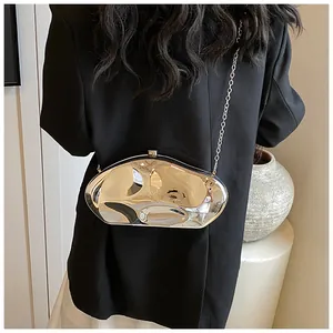 Polished silver irregular molten metal clutch bag with slim chain on a person