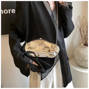 Detail of silver liquid metal acrylic handbag with reflective mirror finish and chain