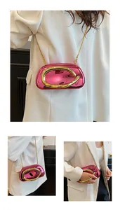 Macro view of metallic fuchsia clutch with bold gold ring and elegant chain strap