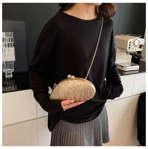 Detail of acrylic marble evening bag with gold sphere clasps and metal chain strap