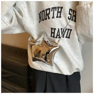 Detalle del bolso bandolera plateado con forma de estrella y acabado metálico con cadena