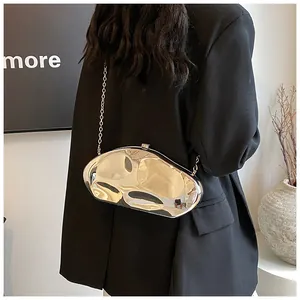 Silver irregular metallic evening clutch with chain strap shown in a minimalist scene