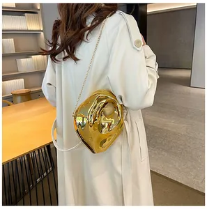 Modern gold irregular liquid-metal crossbody bag with chain strap on a model