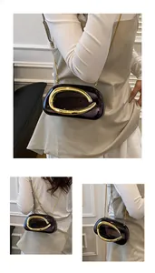 Macro view of luxurious evening clutch bag with golden U-shaped clasp and glossy finish