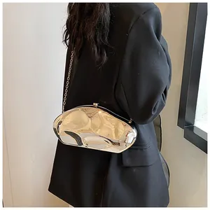 Silver liquid metal crossbody bag with reflective mirror finish and chain strap worn by model