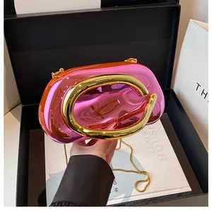 Detail of luxury metallic pink clutch with round gold handle and metal chain strap
