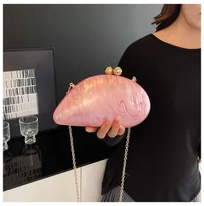 Detailed shot of pink marble acrylic evening bag with gold chain and spherical clasp