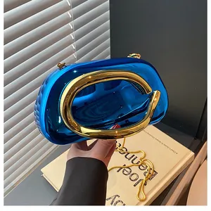 Close-up of luxury mirrored blue clutch with golden circular handle and chain strap