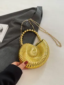 Détail du sac de soirée conque dorée avec poignée en perles et texture métallique chic