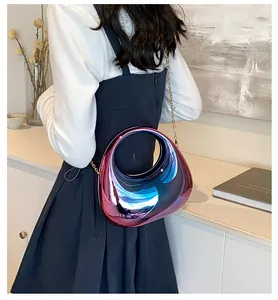 Détail d'un sac futuriste en acrylique irisé avec poignée ronde et chaîne dorée