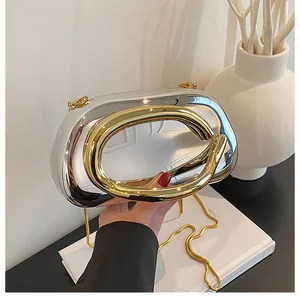 Close-up of luxury metallic evening clutch with gold C-handle and silver mirror finish