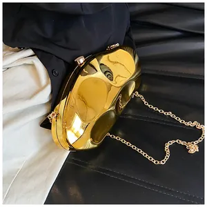 Detail of a shiny gold acrylic evening bag with a unique textured mirror finish