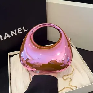 Pink metallic half-moon acrylic handbag with circular handle and gold chain strap