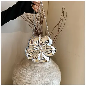 Dettaglio della mini borsa a catena a fiori argento con finitura metallica e petali 3D