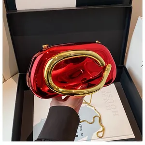 Detail of red metallic evening clutch with golden C-handle and chain in luxury gift box
