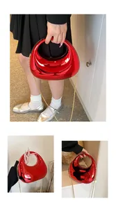 Détail du sac demi-lune rouge effet miroir métallique avec bandoulière dorée