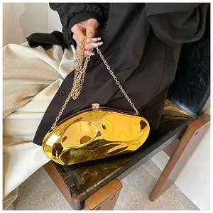 Detail of glossy gold acrylic evening bag with wave shape and chain strap