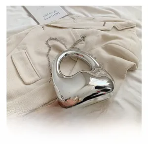 Detail einer herzförmigen silbernen Metallic-Tasche mit eleganter Kette und modernem Stil