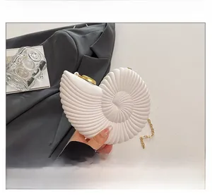Pochette en acrylique blanc en forme de coquillage avec chaîne dorée sur blazer