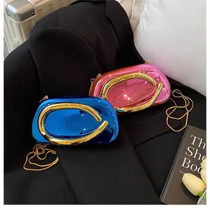 Close-up of metallic blue and pink mirror evening clutches with gold ring handles