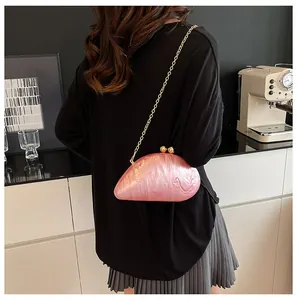 Pink mother-of-pearl acrylic evening clutch with gold chain shown on a female model
